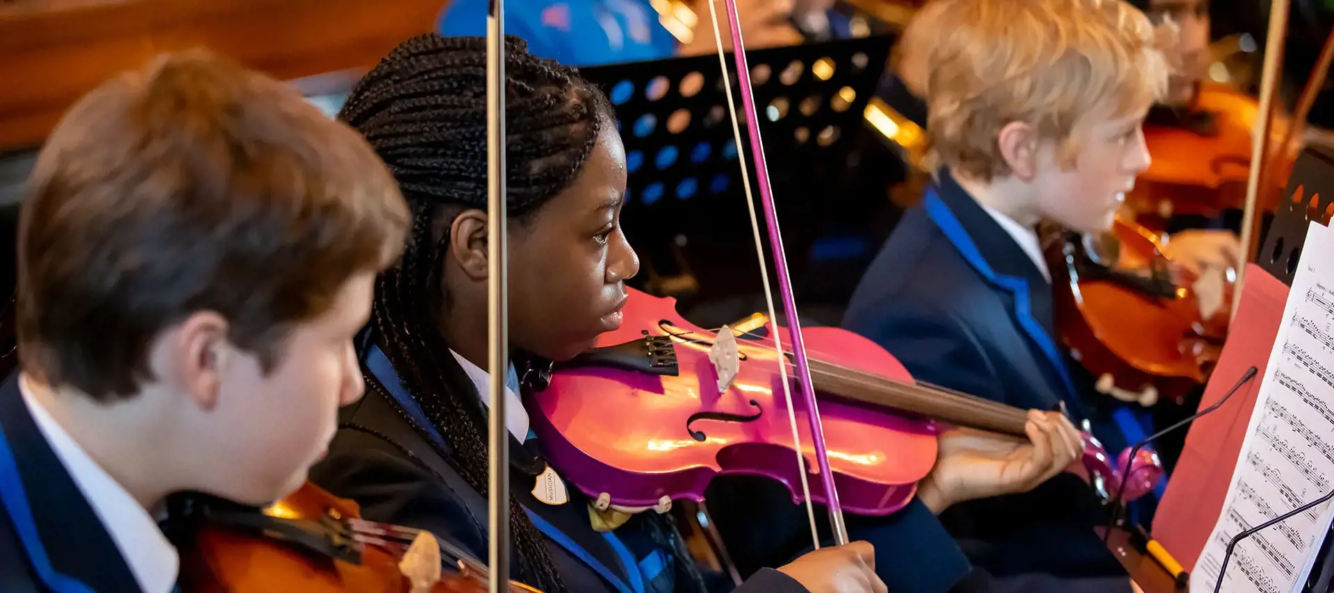 Senior school pupil playing violin in the orchestra at The Gregg School